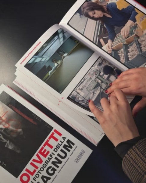 Mani che sfogliano il libro «Olivetti e i fotografi della Magnum»